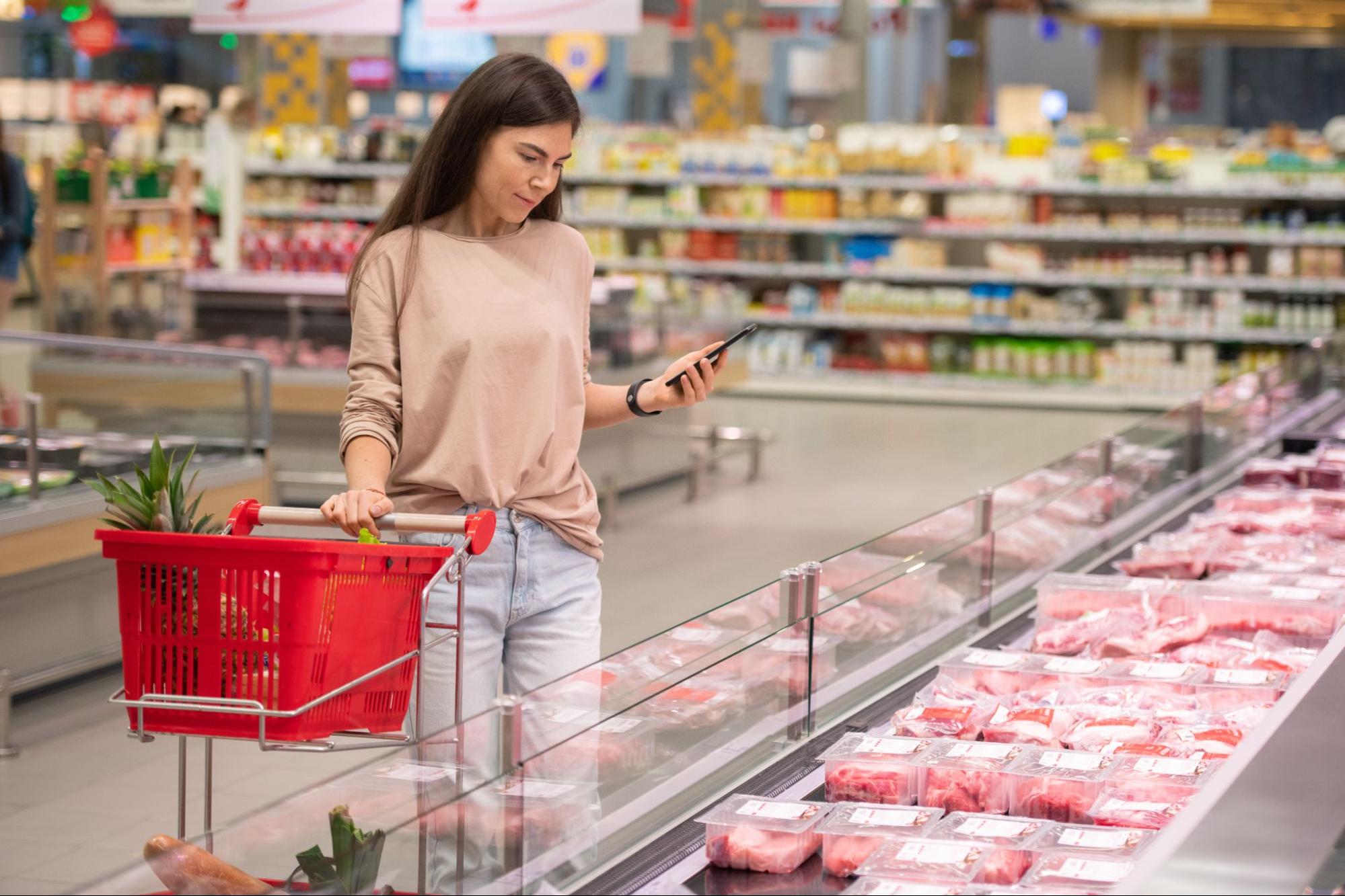 A woman shopping for meat in the grocery