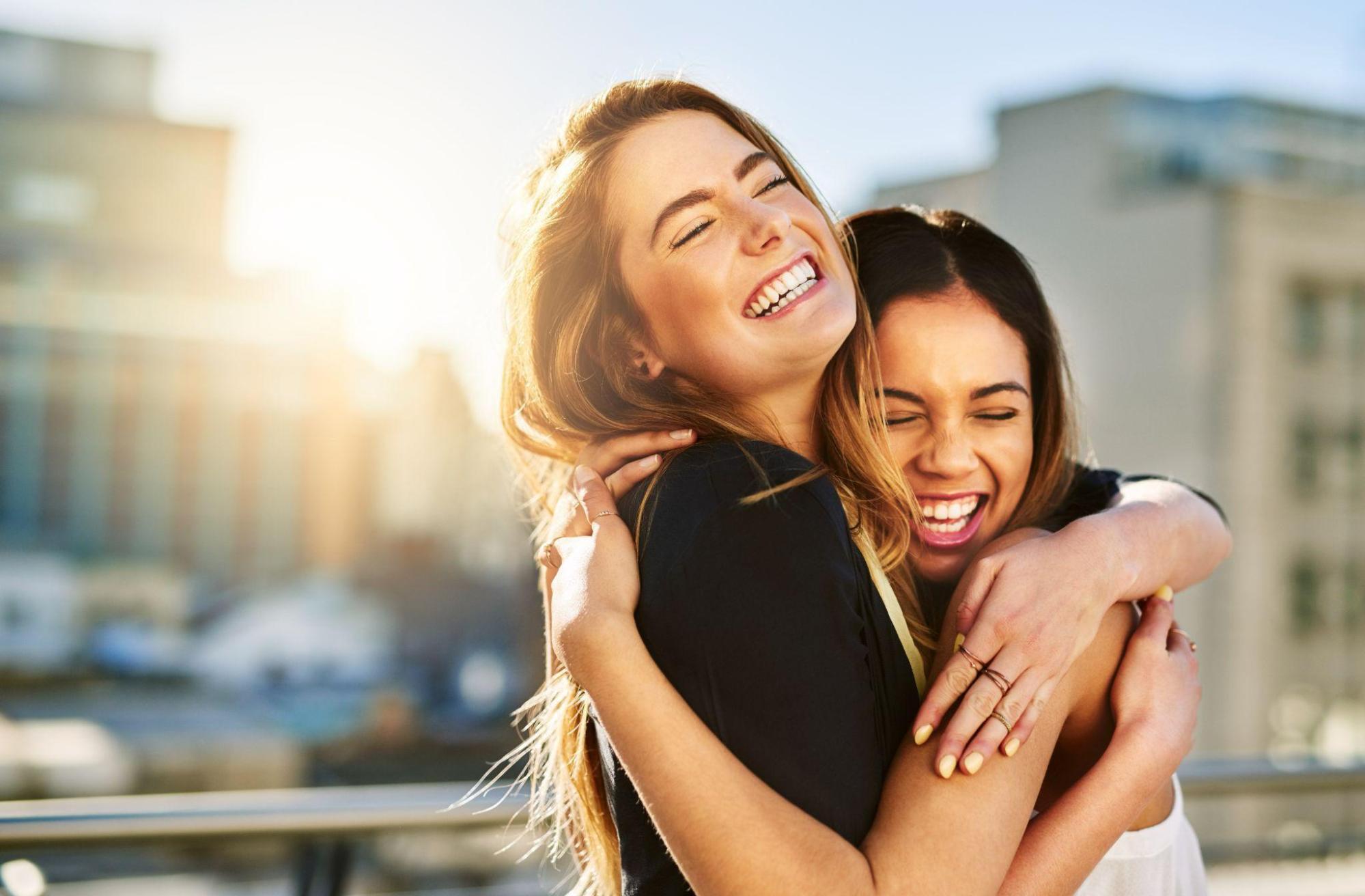 two smiling women hugging each other